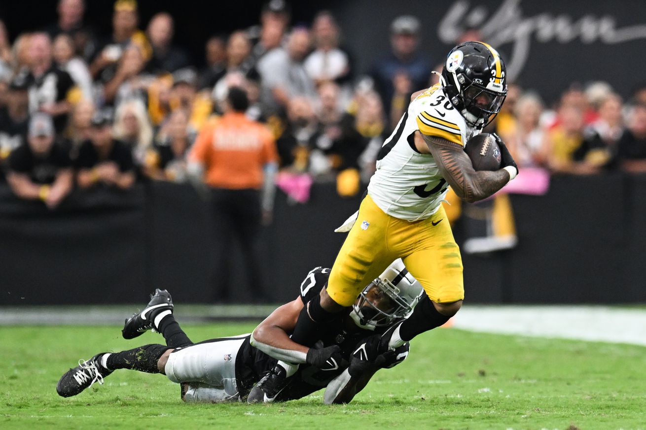 Jaylen Warren #30 of the Pittsburgh Steelers is tackled by Isaiah Pola-Mao #20 of the Las Vegas Raiders in the third quarter of a game at Allegiant Stadium on October 13, 2024 in Las Vegas, Nevada.