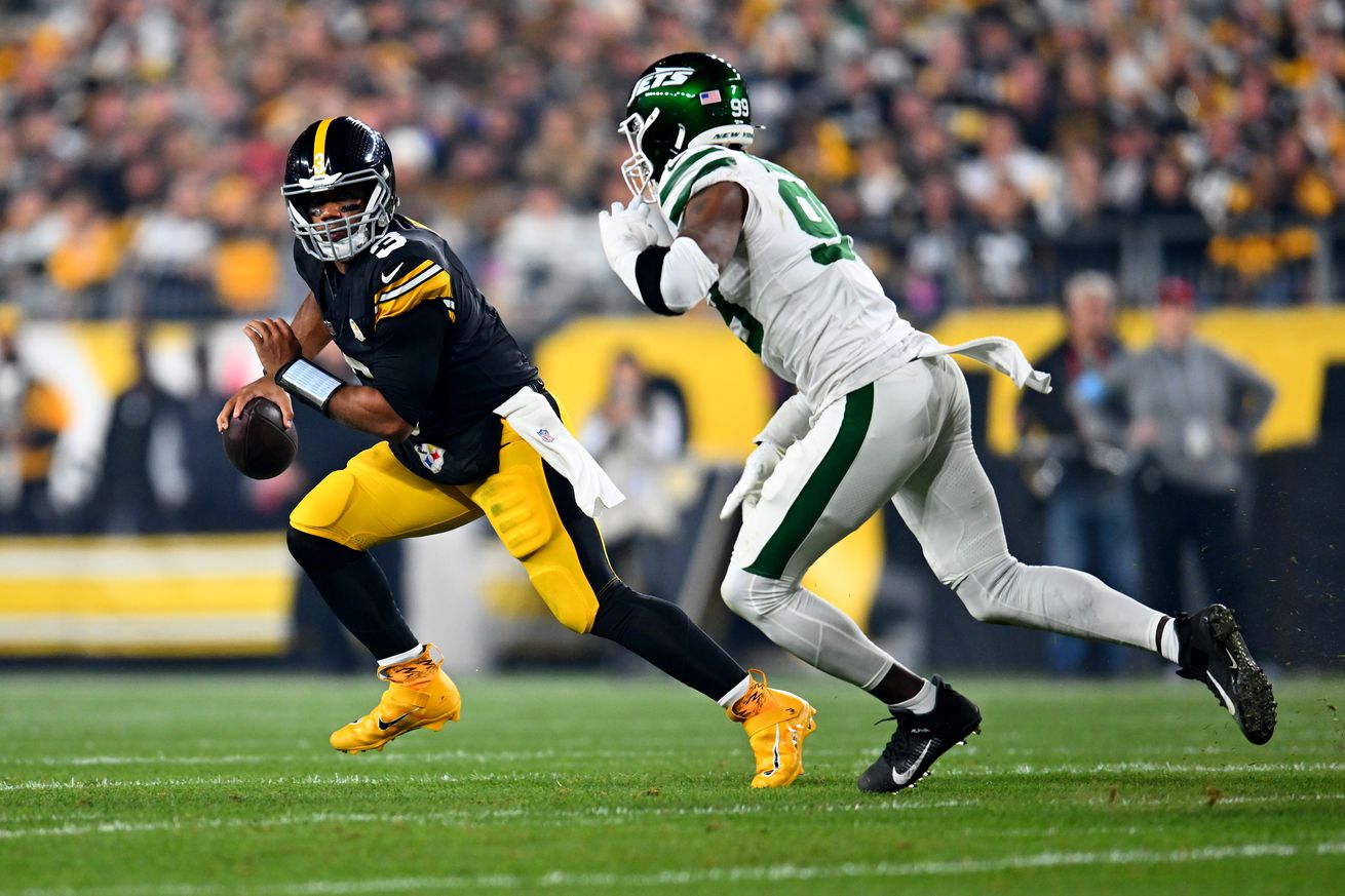 Russell Wilson #3 of the Pittsburgh Steelers scrambles while being pressured by Will McDonald IV #99 of the New York Jets during the first quarter at Acrisure Stadium on October 20, 2024 in Pittsburgh, Pennsylvania.