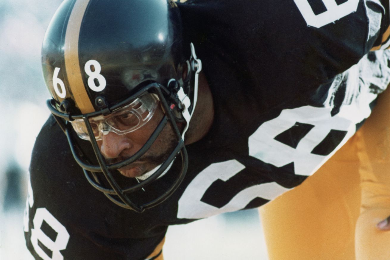 Close-up of American football player L.C. Greenwood of the Pittsburgh Steelers as he crouches on the field, eyeing his opponant, 1970s.