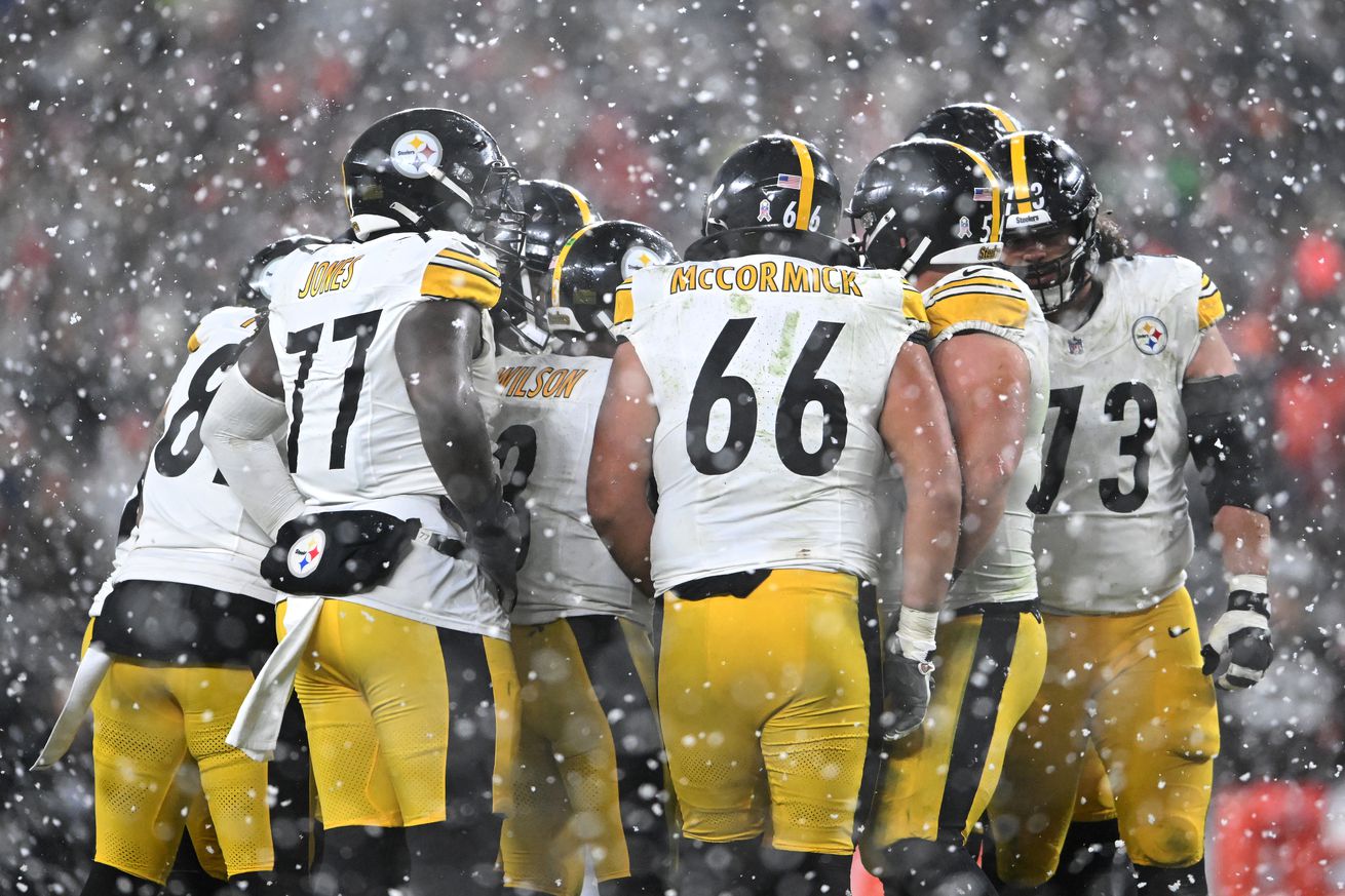 The Pittsburgh Steelers huddle as snow falls against the Cleveland Browns during the third quarter in the game at Huntington Bank Field on November 21, 2024 in Cleveland, Ohio.