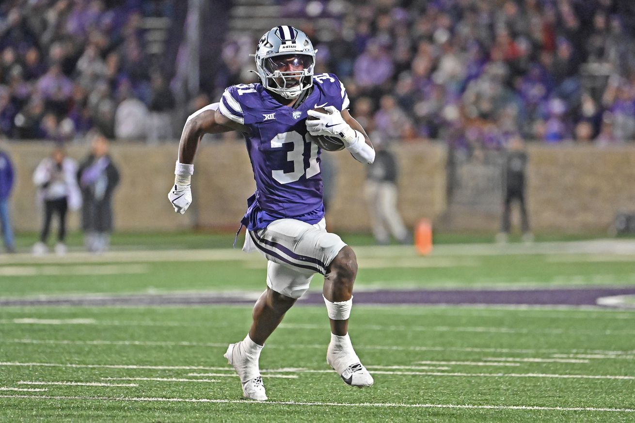 Running back DJ Giddens #31 of the Kansas State Wildcats rushes for a 17-yard touchdown in the second half against the Cincinnati Bearcats at Bill Snyder Family Football Stadium on November 23, 2024 in Manhattan, Kansas.