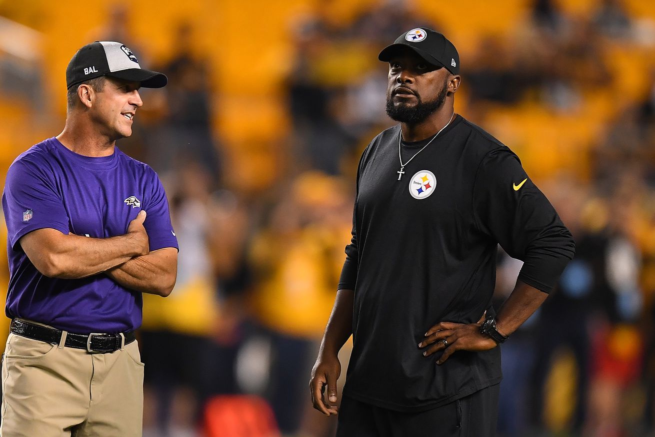 head coach Mike Tomlin of the Pittsburgh Steelers talks with head coach John Harbaugh of the Baltimore Ravens during warmups before the game at Heinz Field on September 30, 2018 in Pittsburgh, Pennsylvania.